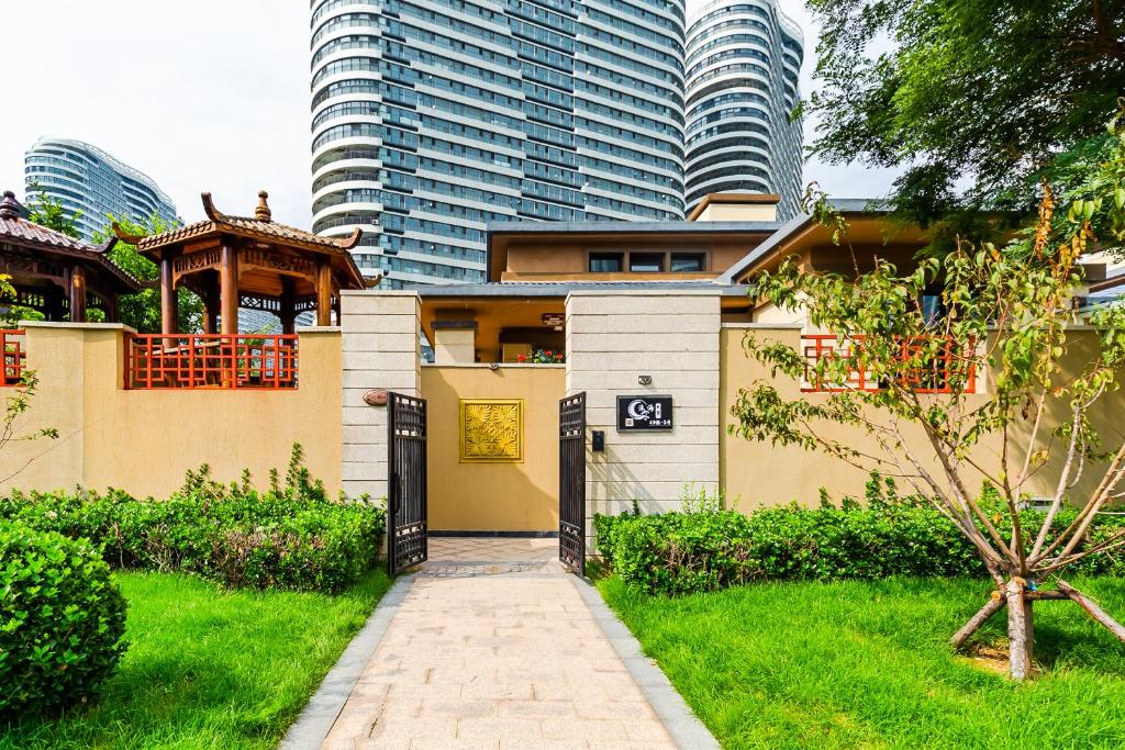 a house in a garden with tall buildings at Fancy Apartment in Suizhong