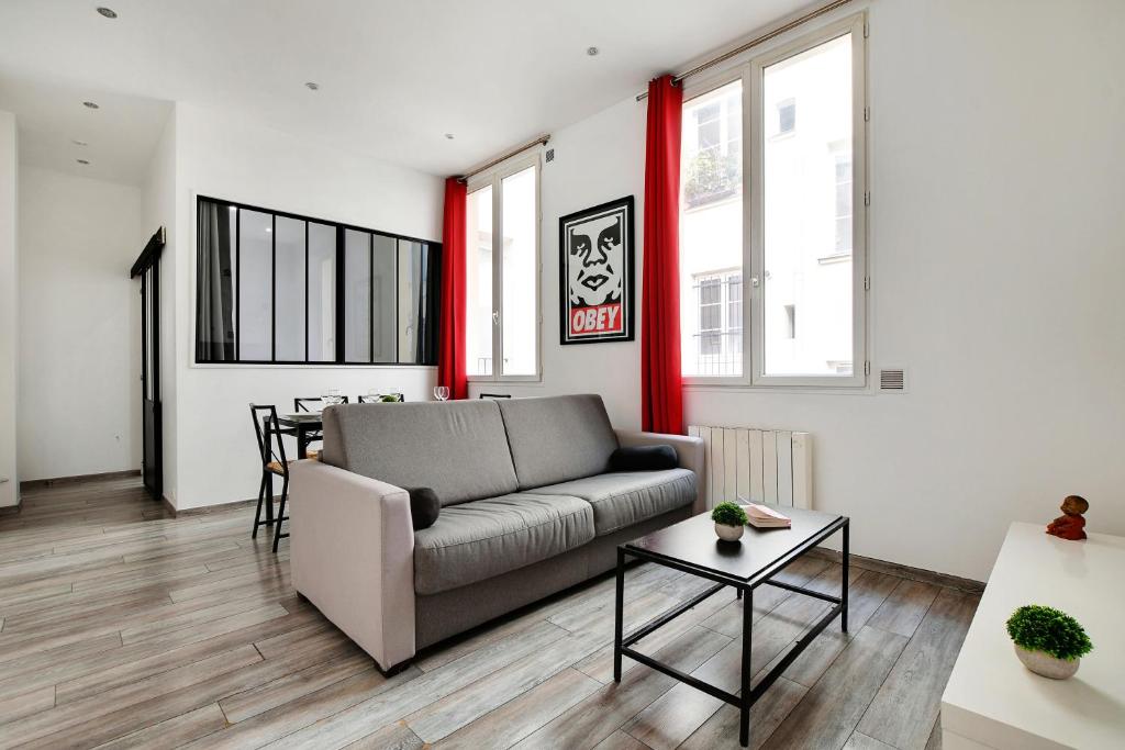 a living room with a couch and a table at CMG Republique - Montorgueil - Vertbois II in Paris