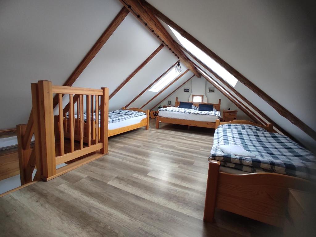Cette chambre mansardée comprend deux lits et un escalier. dans l'établissement Chata nad potokem, à Bělá pod Pradědem