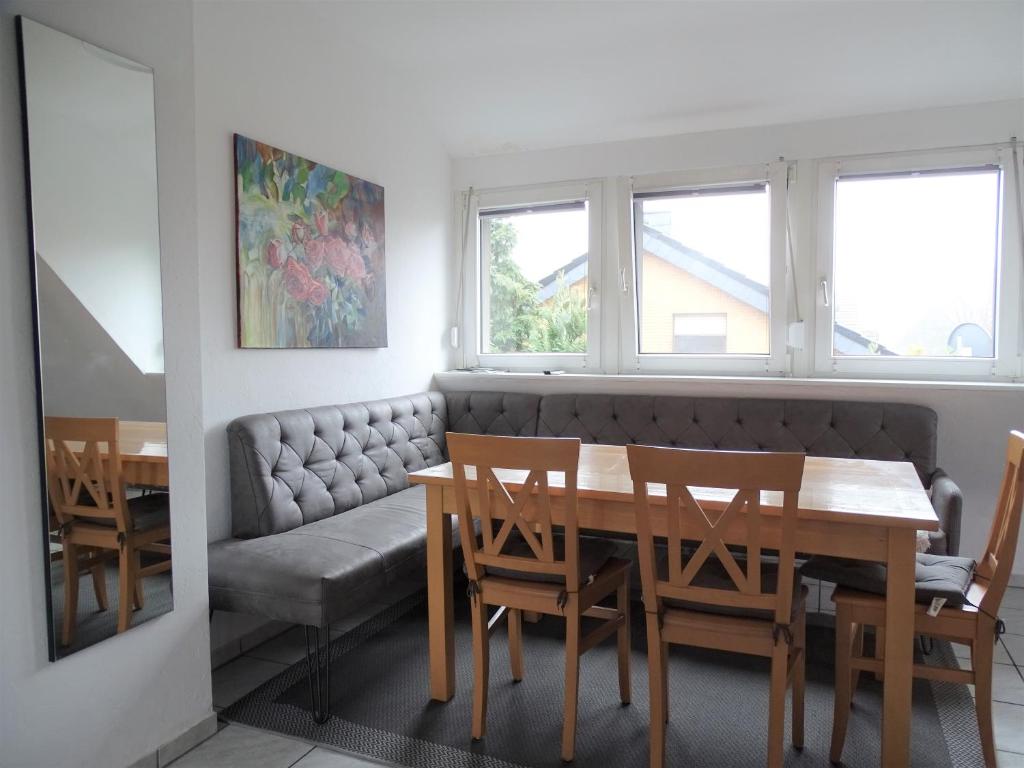 uma sala de jantar com uma mesa e um sofá em Helle Ferienwohnung in Nettetal bei Venlo em Nettetal