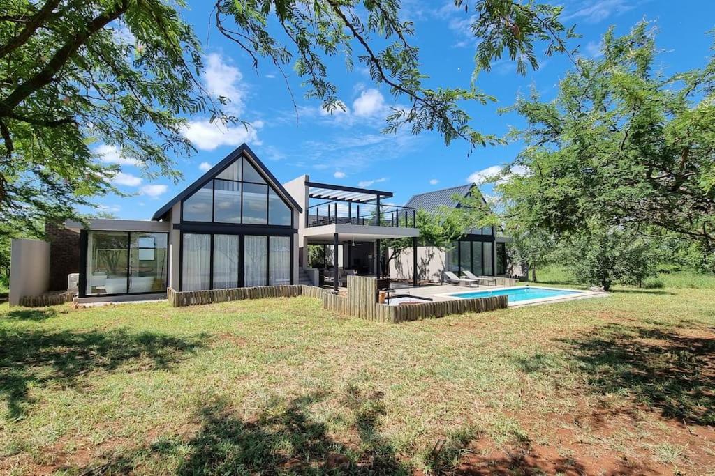 una casa con piscina in mezzo a un cortile di Lindi Lodge, Mjejane Game Reserve a Hectorspruit