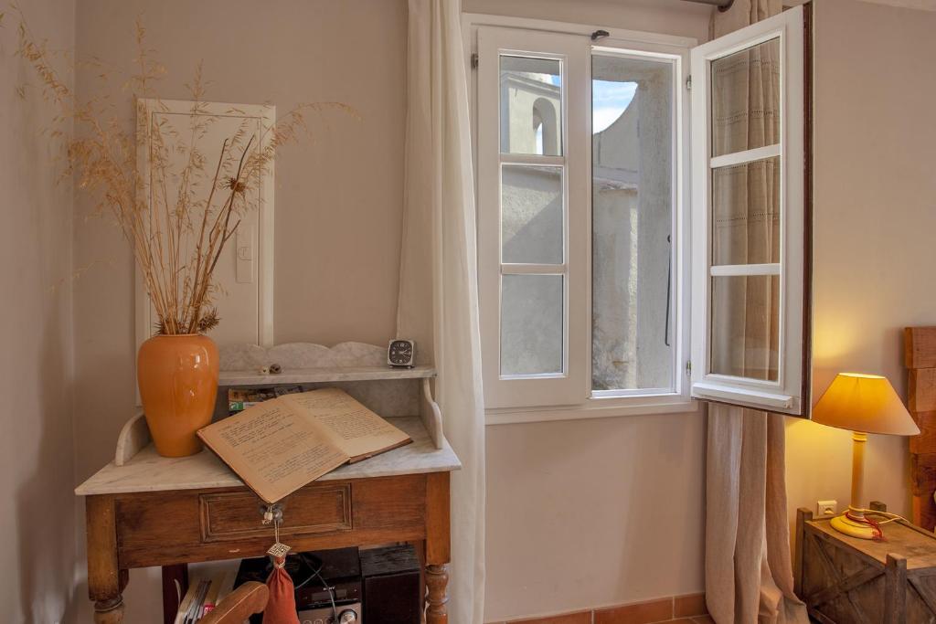 pokój z oknem i stołem z książką w obiekcie Casa Celestina w mieście Pigna