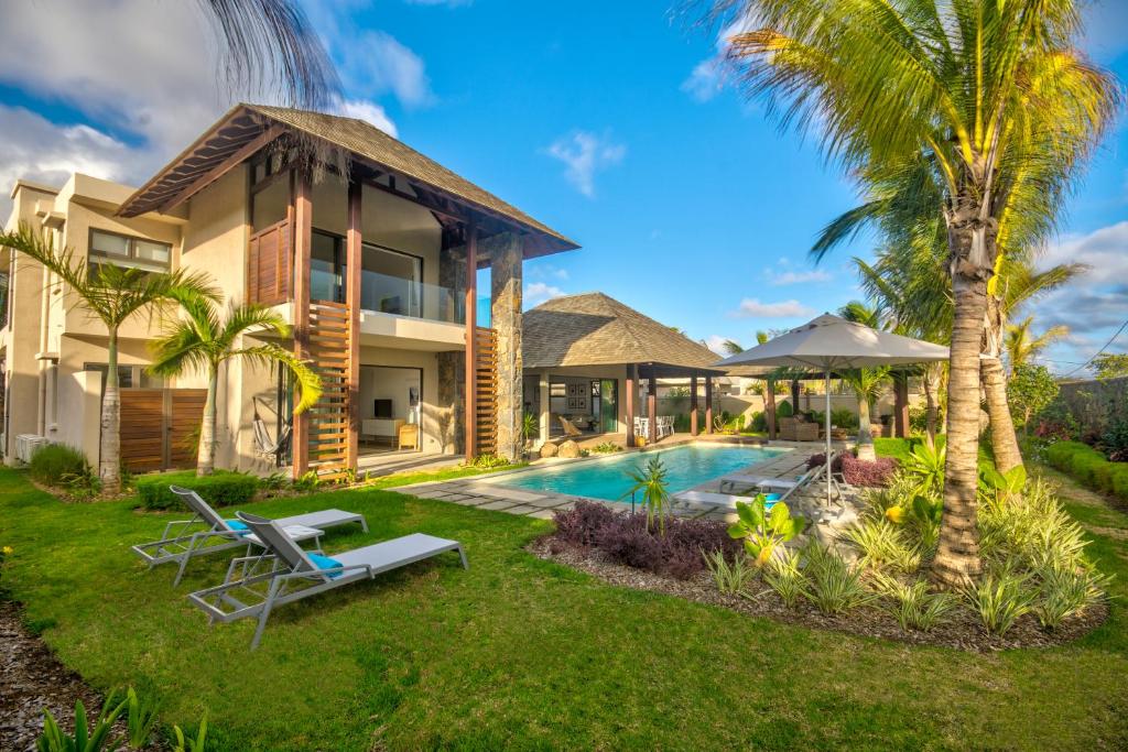 une villa avec une piscine et des palmiers dans l'établissement Mythic Suites & Villas, à Grand Gaube