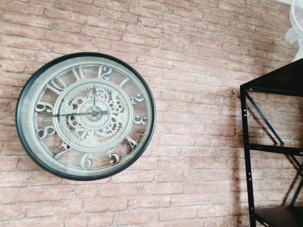 a clock on the side of a brick wall at Esprit industriel au pied du Futuroscope in Chasseneuil-du-Poitou