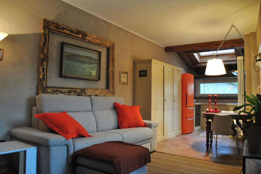 a living room with a gray couch and orange pillows at Casetta Camilla in Varese