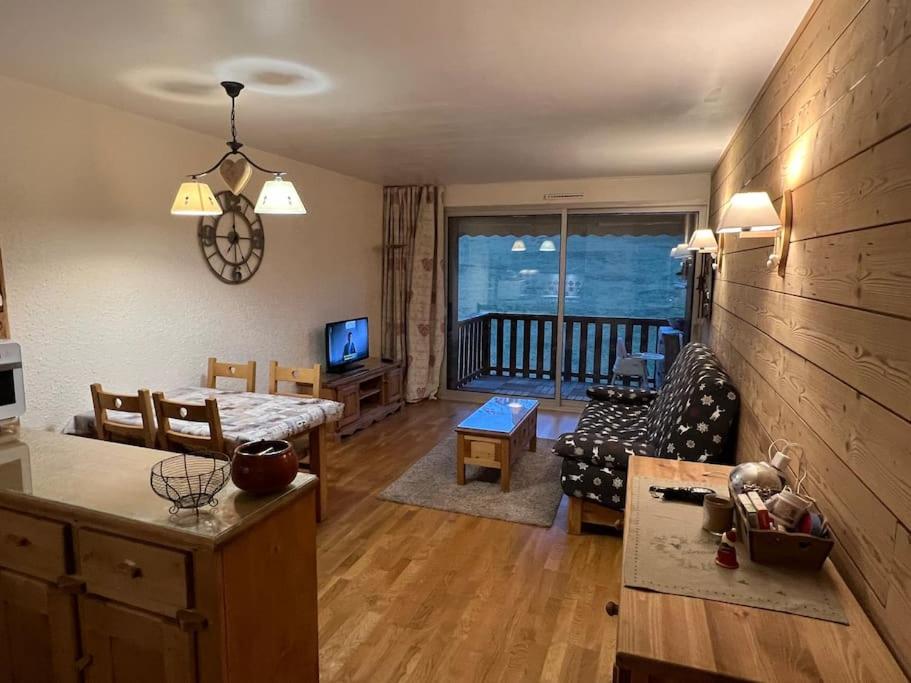 ein Wohnzimmer mit einem Sofa und einem Tisch in der Unterkunft Appartement à Enchastrayes sur piste station de ski au Sauze à 3km de Barcelonnette in Enchastrayes