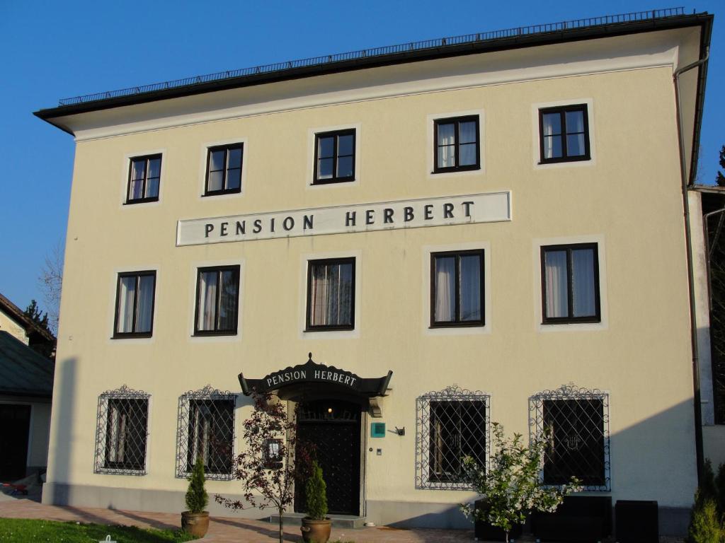 un gran edificio blanco con las palabras permiso Herbert en Hotel Pension Herbert, en Salzburgo