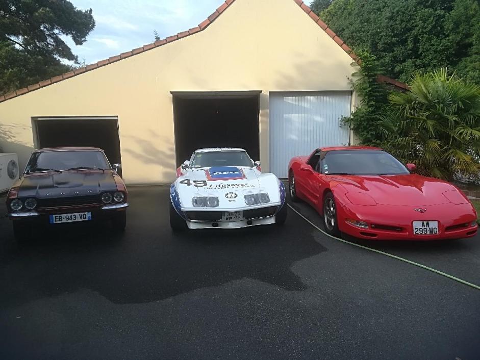 een paar auto's geparkeerd voor een garage bij Chambres in Saint-Mars-la-Brière