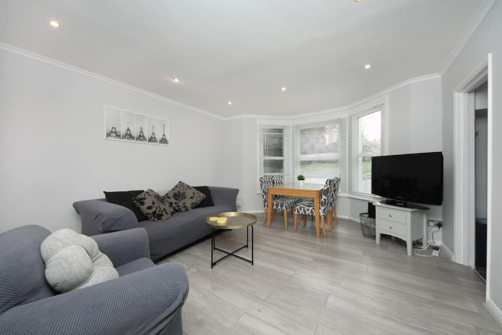 a living room with a couch and a table at Ealing Garden Flat in Ealing