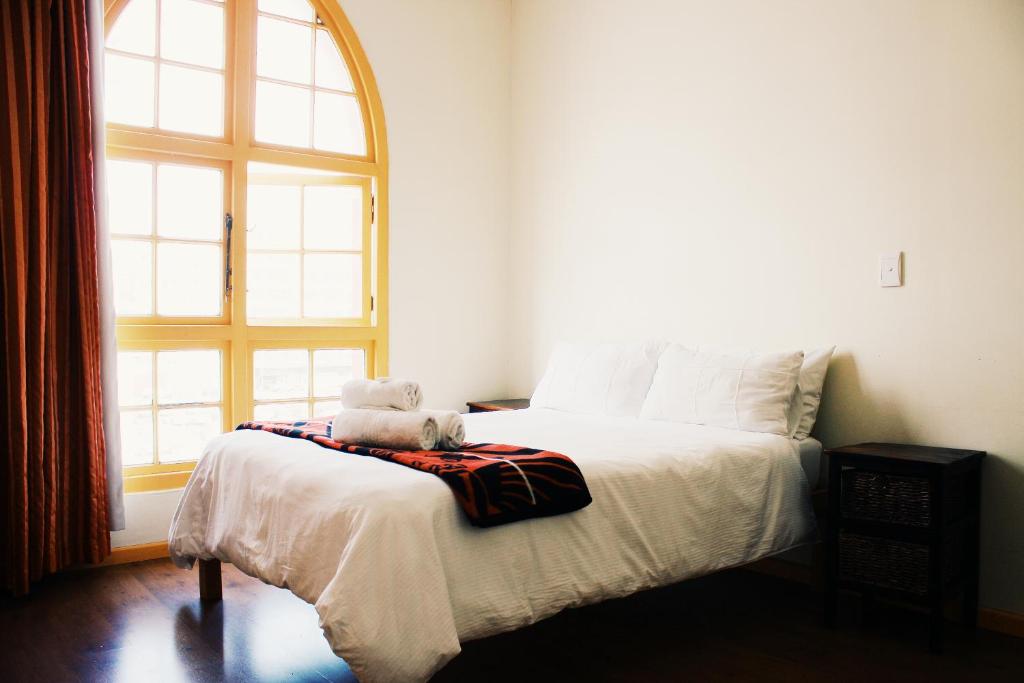 a bedroom with a bed with a teddy bear on it at Scalabrini Accommodation in Cape Town