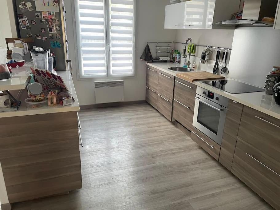 a kitchen with stainless steel appliances and wooden floors at centre Pierrefonds superbe appartement + parking in Pierrefonds