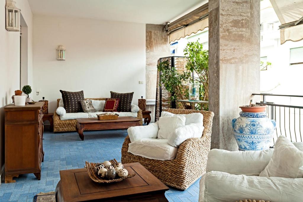 a living room with wicker chairs and a table at Casa Azul in Sorrento