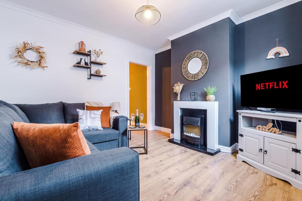 salon z niebieską kanapą i telewizorem w obiekcie Stylish 2-Bed City-Centre Home in Chester by 53 Degrees Property - Ideal for Couples & Groups - Sleeps 6 w mieście Chester