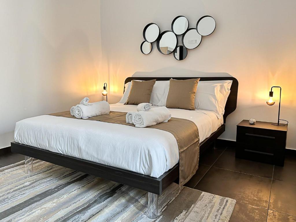 ein Schlafzimmer mit einem großen Bett mit Spiegeln an der Wand in der Unterkunft Marbel Suite in Adelfia