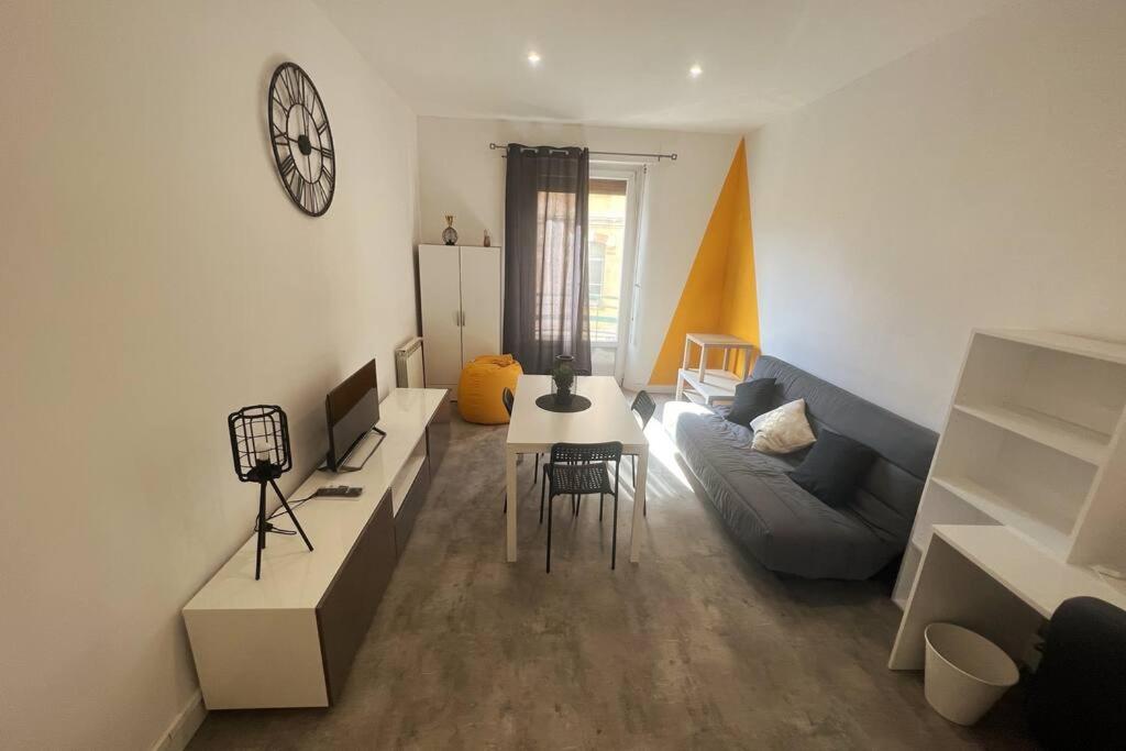 uma sala de estar com um sofá e uma mesa em Label Etape - 2min GARE - WIFI - TeRRaSSe em Marselha