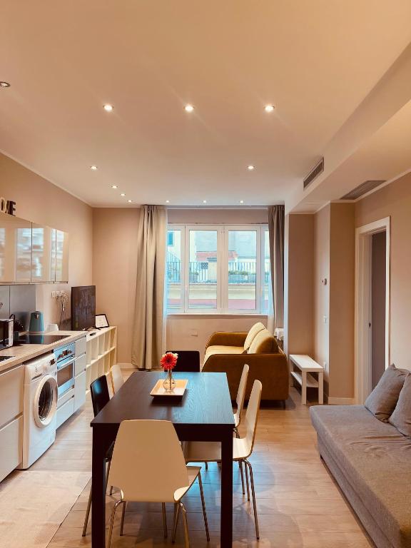 a kitchen and living room with a table and a couch at Urban Chic Home in Bari