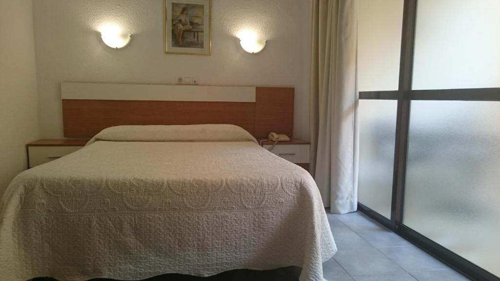 a hotel room with a bed and two lamps at Pension Terminal in Málaga