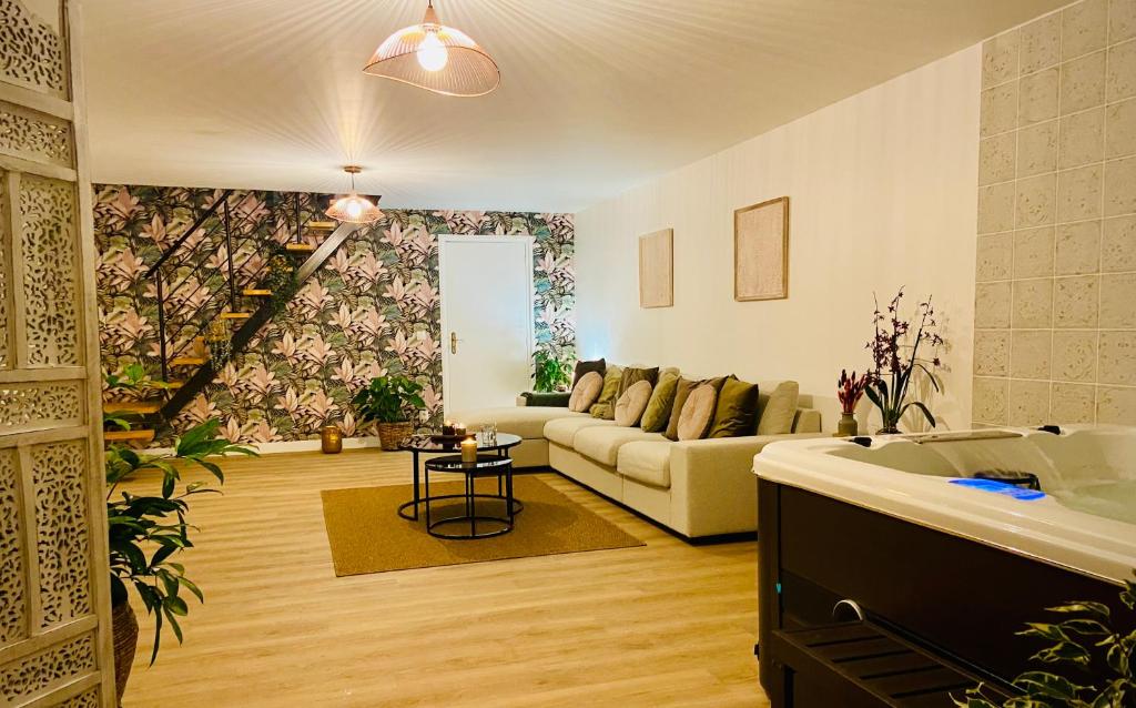 een woonkamer met een bank en een bad. bij Blossom Break - logement et spa in Lezennes