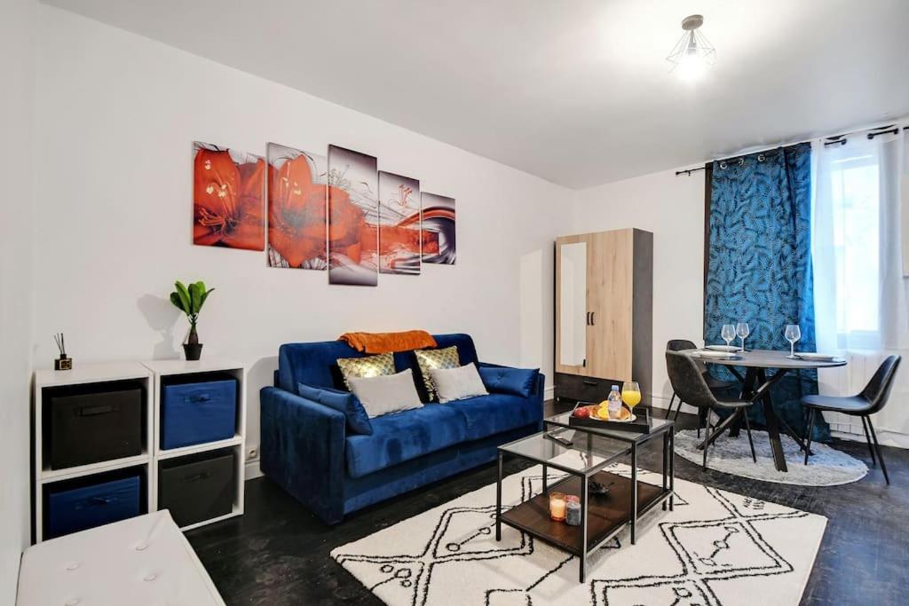 - un salon avec un canapé bleu et une table dans l'établissement Cosy appartement aux Portes de Paris, à Aubervilliers