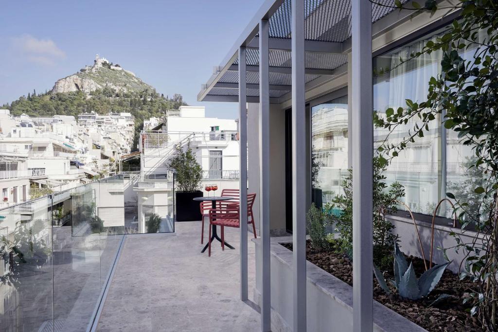 a balcony of a house with a table and chairs at The Social Athens Hotel, a member of Radisson Individuals in Athens