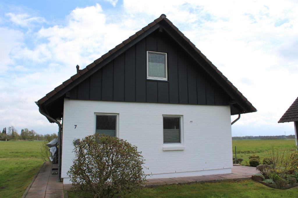 une maison blanche avec un toit noir dans l'établissement KM 7 - Deichgraf 2 Standard, à Bad Bederkesa