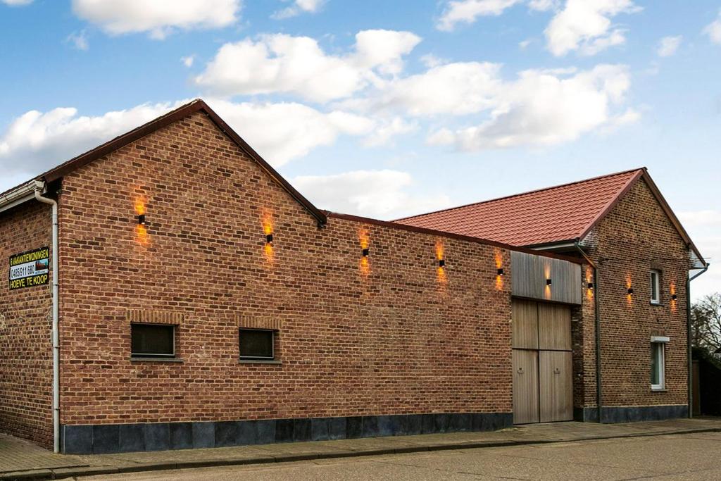 un gran edificio de ladrillo con garaje en Vakantiewoning Henisdael en Heers