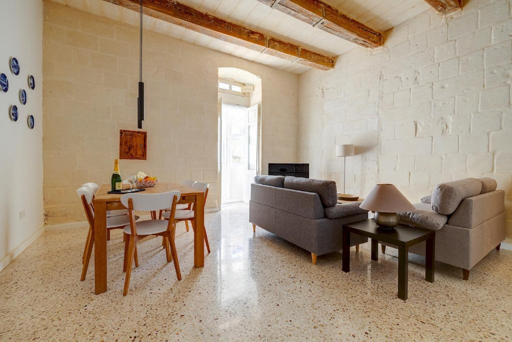 un soggiorno con un divano e un tavolo di Comfy 2 BR Flat in the Heart of Valletta a La Valletta