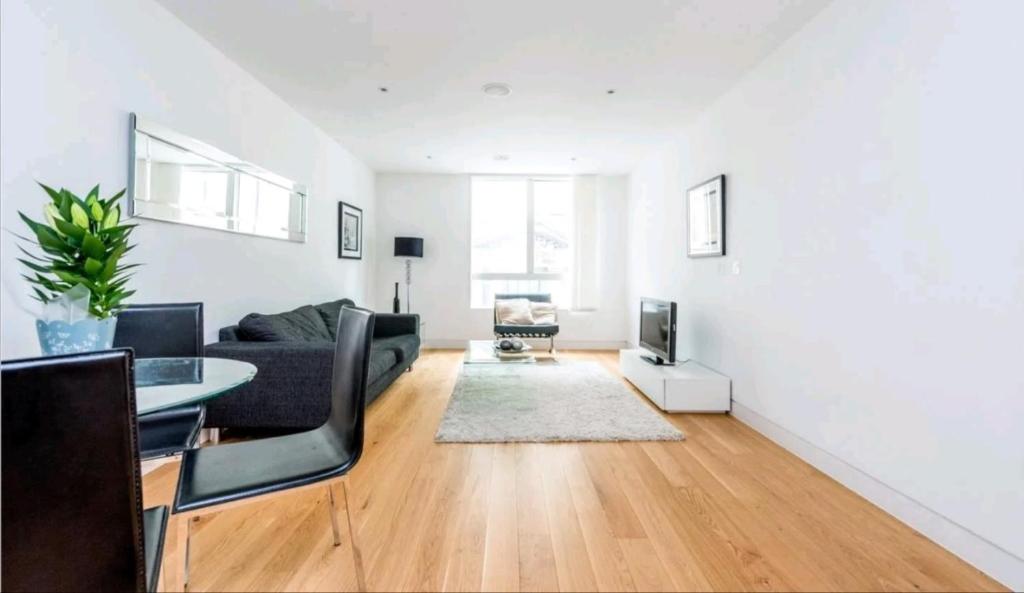 ein Wohnzimmer mit einem Sofa und einem Tisch in der Unterkunft Luxury Holiday Let @ London City in London