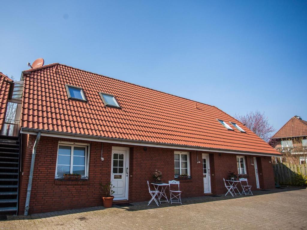 une maison en briques rouges avec un toit orange dans l'établissement Apfelhof Wegener Elstar Topaz, à Jork