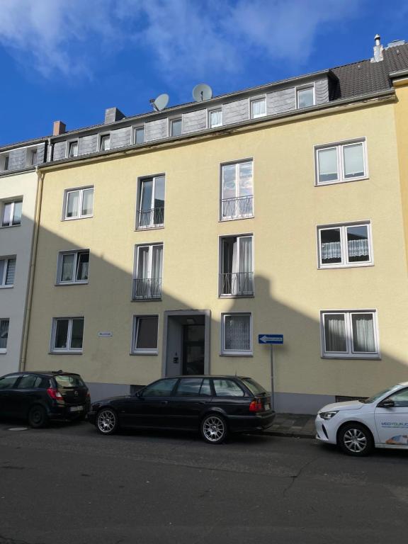 un bâtiment jaune avec des voitures garées devant dans l'établissement estrella24 LIVING ROOMS Chicago, à Remscheid