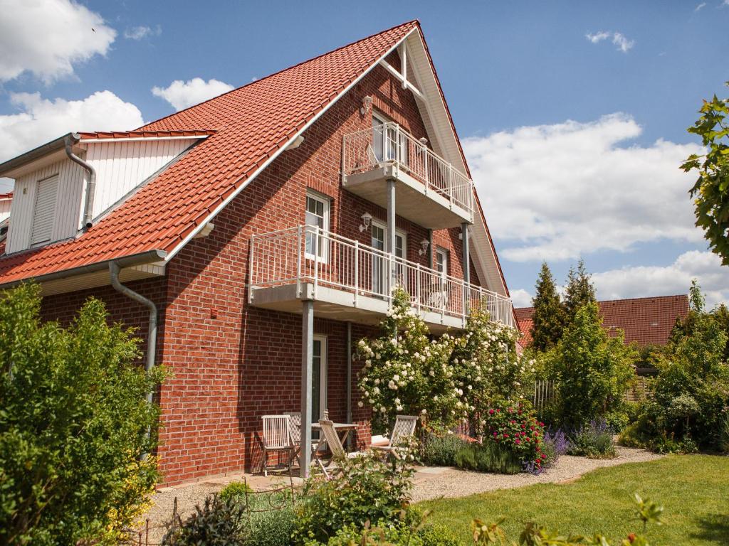 a brick house with a balcony on the side of it at Apfelhof Wegener in Jork