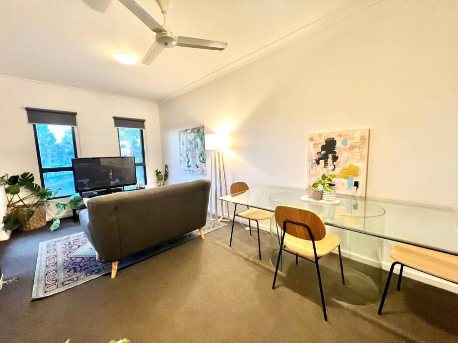 a living room with a glass table and a couch at Stylish Self-contained Apartment in South Hedland