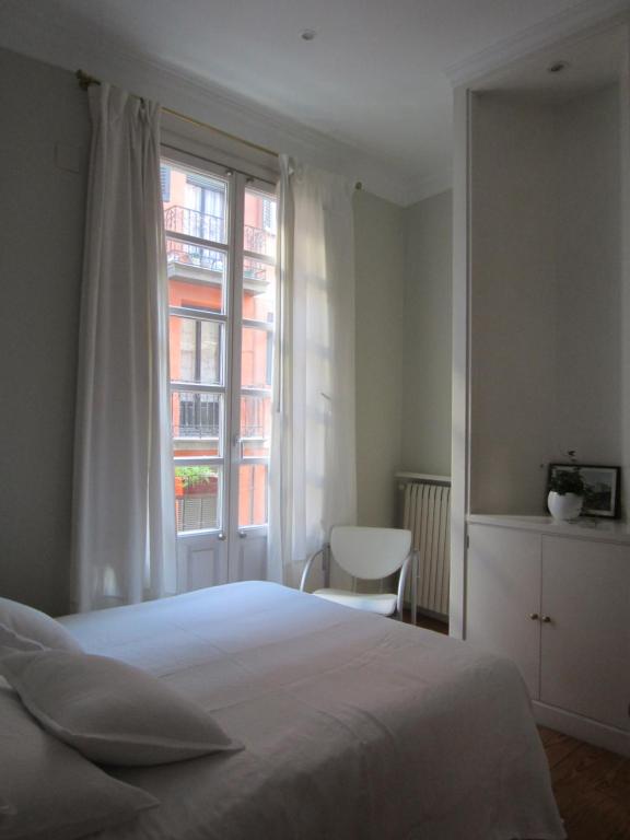 1 dormitorio con cama blanca y ventana en Ekain, en Bilbao
