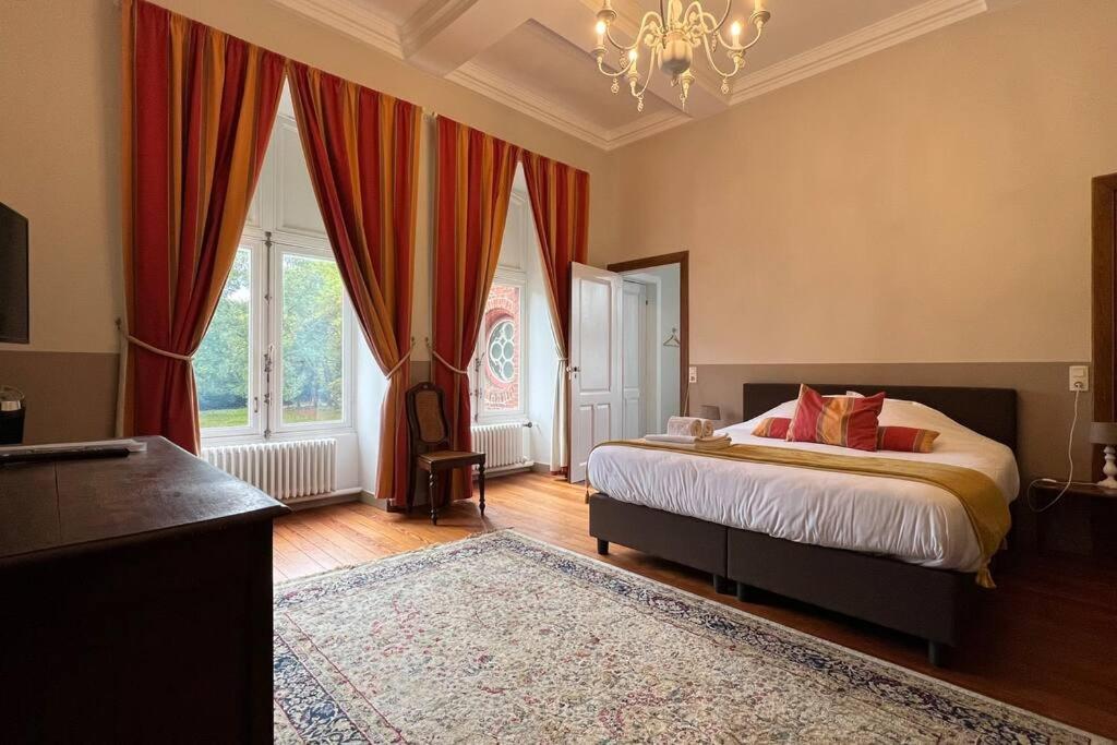 een slaapkamer met een bed en een groot raam bij Castle ten Berghe Château in Brugge