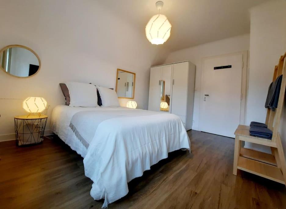 a bedroom with a large white bed and a mirror at Rooms 6 persons Kaysersberg in Kaysersberg