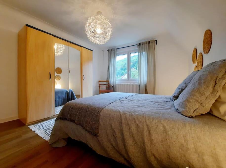 a bedroom with a large bed and a chandelier at Rooms 6 persons Kaysersberg in Kaysersberg