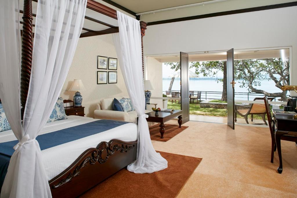 a bedroom with a bed and a view of the ocean at EKHO Lake House in Polonnaruwa