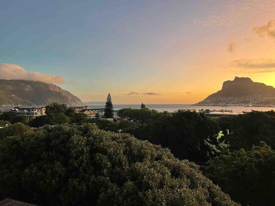 豪特灣的住宿－Chapman`s Peak, Loft mit Sea-und Mountainview，日落时分海滩和山脉美景