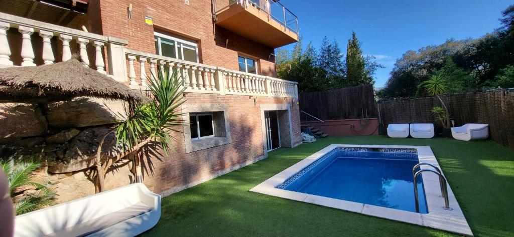 een achtertuin met een zwembad naast een gebouw bij Casa en Alella, Barcelona in Alella