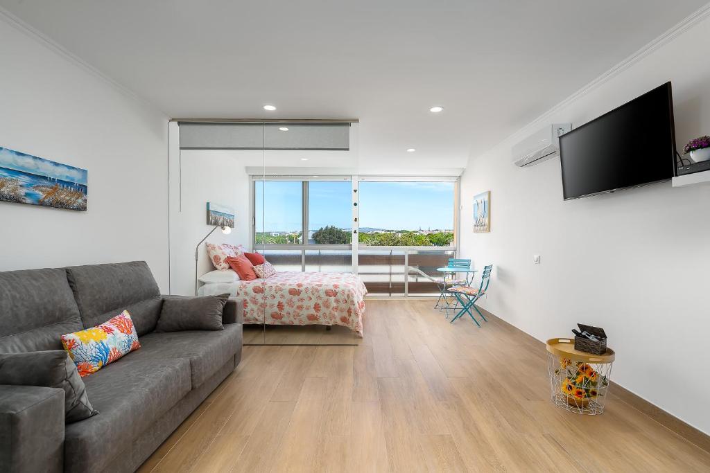 un soggiorno con un divano e una camera da letto di Apartamento Algarve, located center of Vilamoura a Quarteira