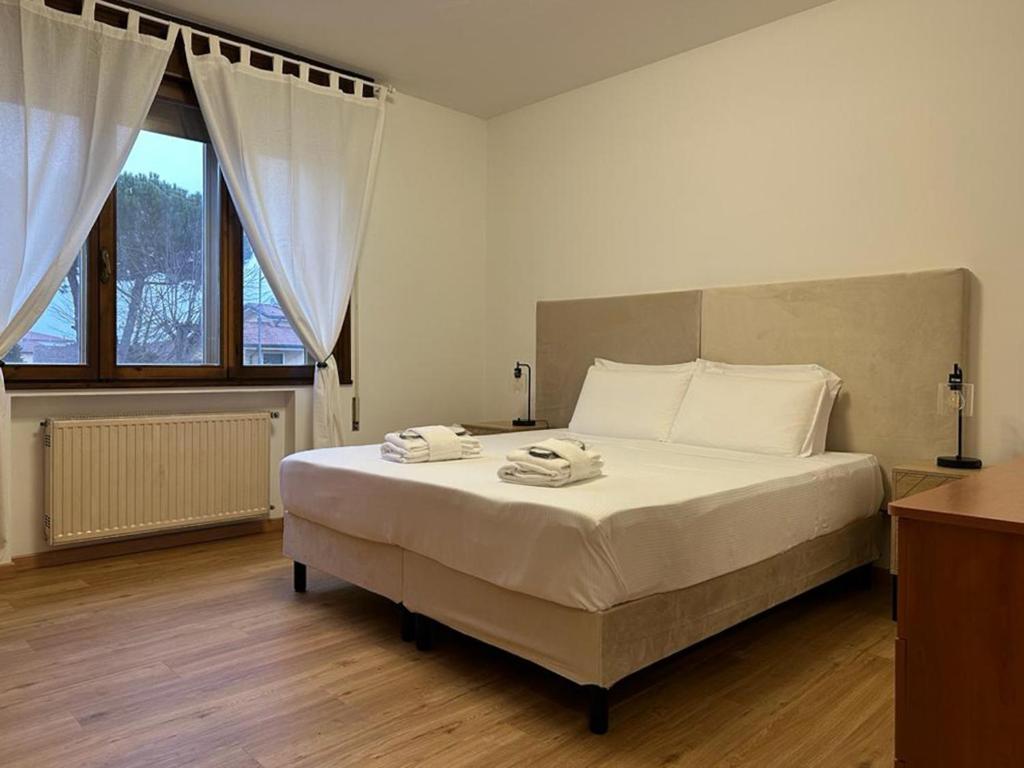 een slaapkamer met een groot bed en 2 handdoeken bij Due Carrare Business in Due Carrare