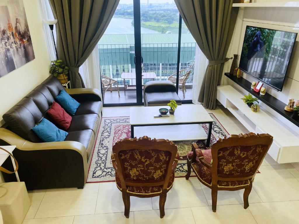 a living room with a couch and a table and chairs at Mines Astetica Lake View Condo Seri Kembangan v1 in Seri Kembangan