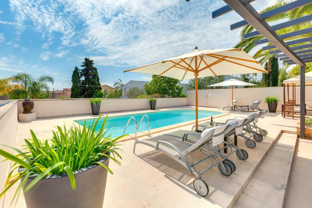 uma piscina com duas cadeiras e um guarda-sol em Guesthouse Palma - Suite Arabella Apartment, Adults Only em Palma de Maiorca