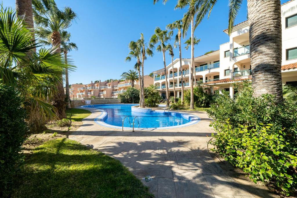 un complejo con piscina con palmeras y un edificio en Costa Linda 201 en Hospitalet de l'Infant