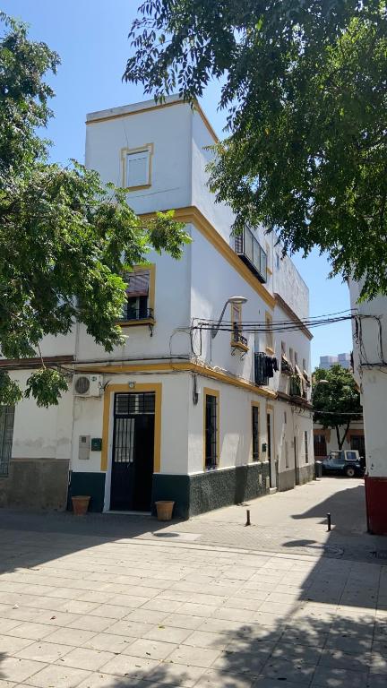 un gran edificio blanco con una puerta en una calle en Apartamentos Triana - Aloha Sevilla, en Sevilla