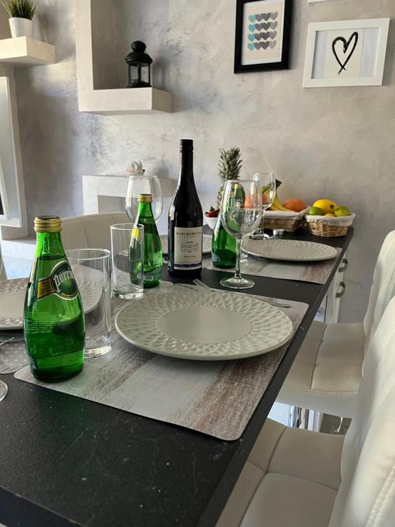 a table with a plate and two bottles of wine at Elegant Stay in the Heart of Plovdiv Old Town in Plovdiv