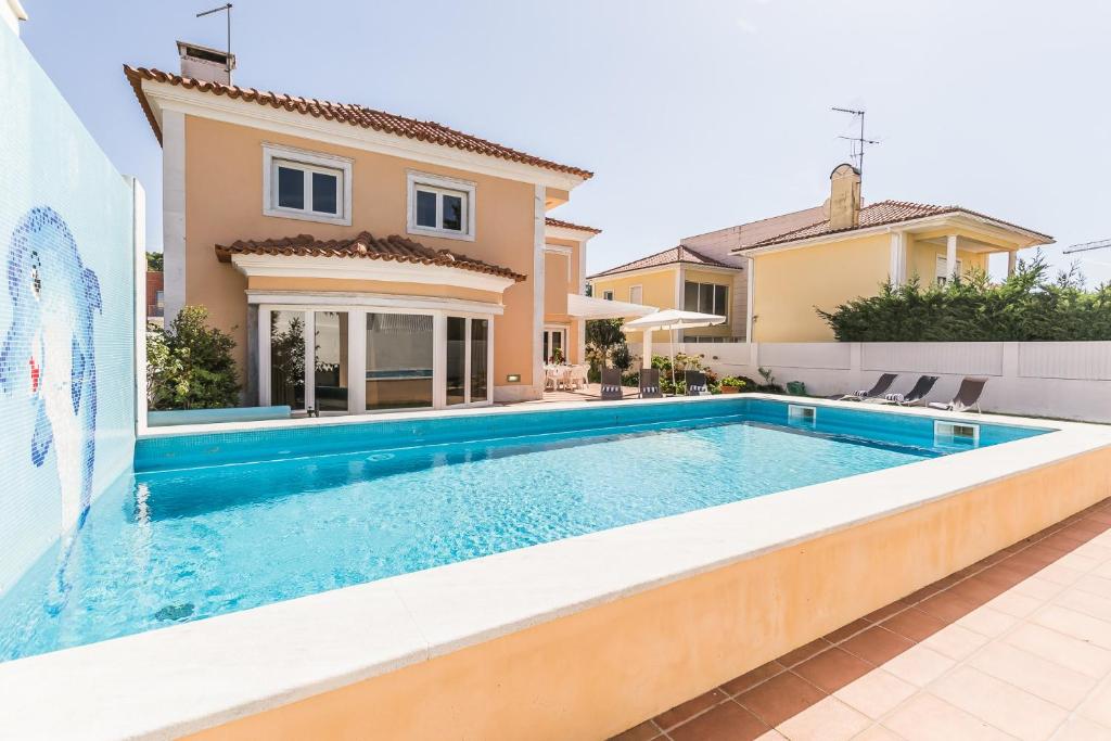 a swimming pool in front of a house at Villa Quinta da Marinha II in Cascais