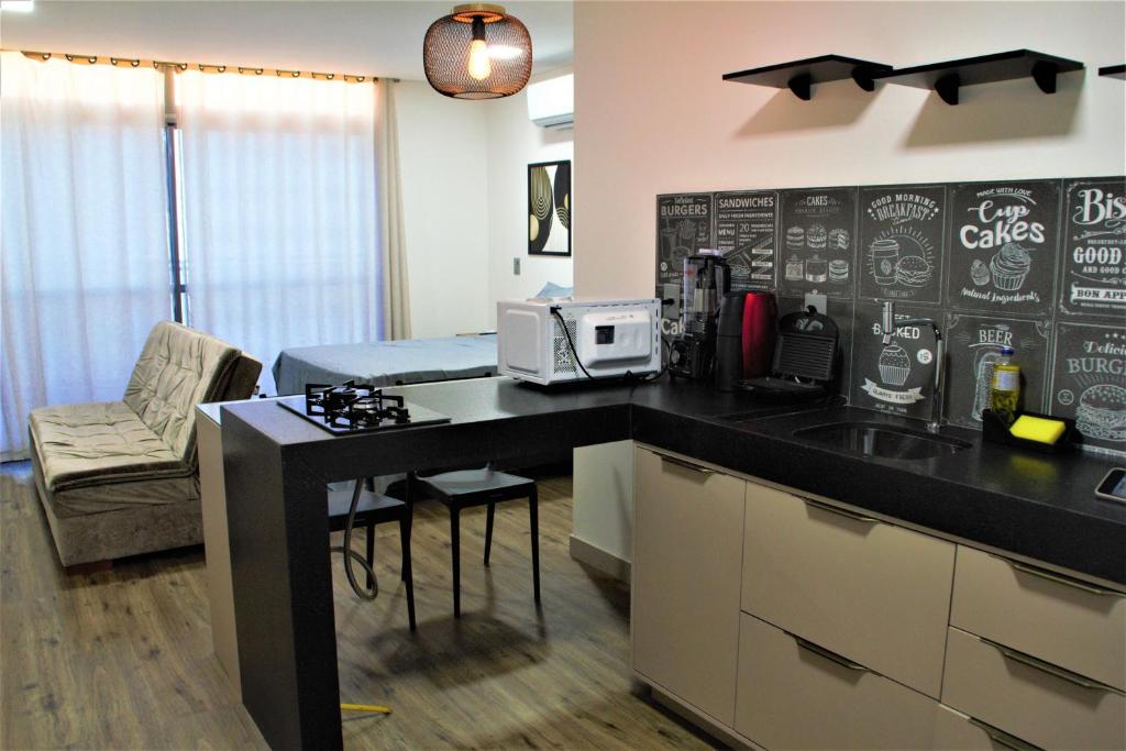 una cocina con encimera negra y una habitación en apartamento para até 4 pessoas, en João Pessoa