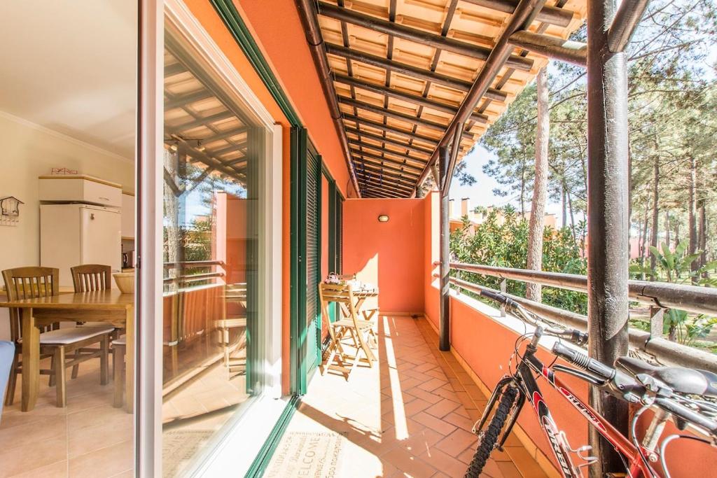 uma casa com uma varanda com uma mesa e uma bicicleta em Apartment Anibal em Aroeira