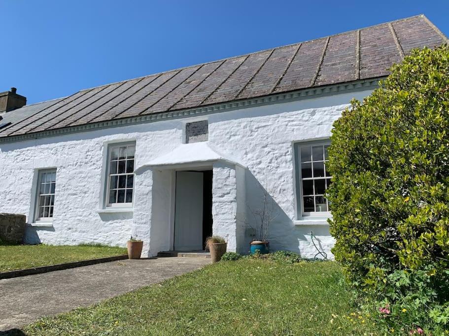 a white building with a door in the yard at The Old Chapel in St. Davids